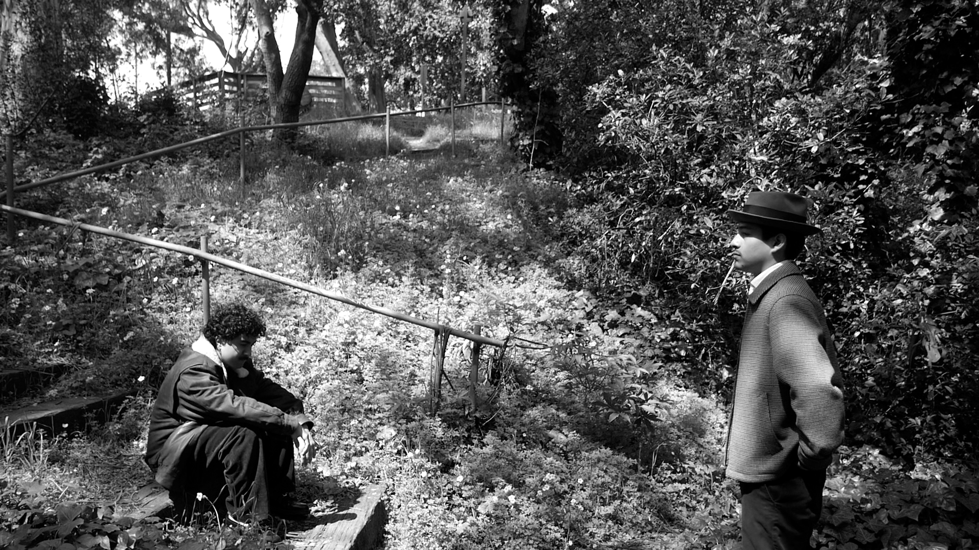 A tense moment between two characters in an overgrown garden